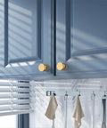 Champagne Bronze Knurled Cabinet Knobs, 1.2 Inch Diameter, installed on blue cabinets, single hole mount, zinc alloy hardware.