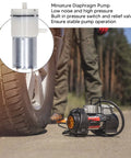 Boss Level 12V Micro Air Pump Featuring Rock Solid Aluminum Body, Self Priming Diaphragm Vacuum Pump Offering Ultra Quiet Operation, Dual Output Valves, Built In Pressure Switch, No Mess Setup For Aquariums And Home Projects. Mini diaphragm pump beside tire, showcasing aluminum construction and low noise operation.