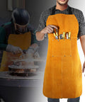 Man wearing Heavy Duty Leather Welding Apron, Flame and Spark Resistant Bib, adjusting neck strap, background of welding sparks