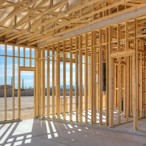 Interior framing of a building with wooden studs and beams under construction, showcasing structure support.