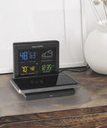 Weather Forecaster Alarm Clock With Wireless Qi Charging Pad Real Time Indoor And Outdoor Temperature And Humidity Calendar Illuminated LCD Display No Wires Needed on a bedside table