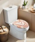 Elongated Liquid abstract marble painting print rose gold Toilet Seat on modern white toilet in bright bathroom setting.