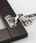 Close-up of Stainless Steel Hydraulic Hinge Core Damper Buffer Cabinet Hinges on a dark wood cupboard door frame