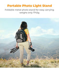 Person holding Heavy Duty Light Stand for Photography 9.1ft Extendable Tripod Built Tough with Stable Base in outdoor setting