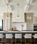 MQMQA 2 Pack Globe Pendant Lights, Mid Century Brass Pendant Light Fixtures hanging over modern kitchen island with clear glass shades.