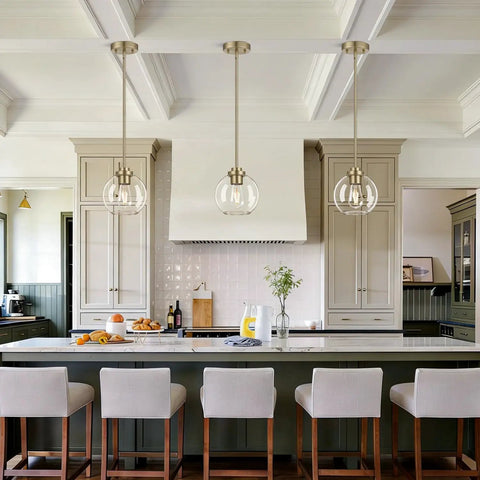 MQMQA 2 Pack Globe Pendant Lights, Mid Century Brass Pendant Light Fixtures hanging over modern kitchen island with clear glass shades.