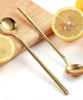 Gold Tone 6.7 Inch Long Handle Coffee And Tea Spoons Set Of 4 Stainless Steel Dope Stirring Spoons with lemons on a wooden board