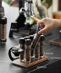 Single Dose Coffee Storage Tubes With One Way Exhaust Valve 8 Piece Set, espresso dosing jars in walnut holder on countertop.