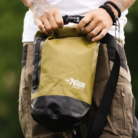 Person holding olive ExoDry 30L Large Drybag Waterproof With Roll Top Closure And Backpack Style Straps