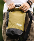 Person holding Pelican ExoDry 10L dry bag with roll-top closure for kayaking