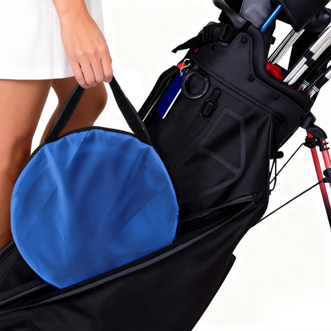 Person carrying blue bag with Set Of 3 Golf Chipping Nets With 12 Inch, 18 Inch, And 24 Inch Pop Up Targets in golf bag.