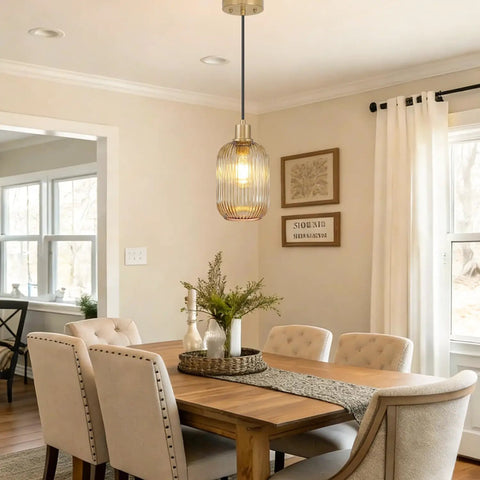 Two Pack Top Tier Amber Cylinder Pendant Lights With Vintage Ribbed Hand Blown Glass And Brushed Gold Adjustable Fixtures serving a dining area.