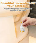 Adorable Ceramic Duck Toilet Bolt Covers Two Pack Decorative Screw Caps With Slick White Finish And Universal Fit shown near toilet.
