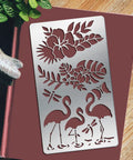 Heavy Duty Metal Flamingo And Butterfly Cutting Template Four By Seven Inches Reusable Patterns For Card Making Wood Burning Leather Crafting Spray Painting Badass Craft Gear on maroon background.