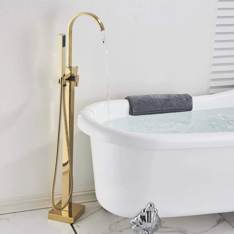 Solid Brass Freestanding Bathtub Faucet With Hand Shower in Gold Polished Finish next to filled bathtub in bathroom setting