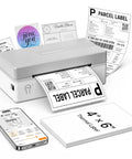 Wireless Bluetooth Thermal Shipping Label Printer Pulls Off Killer 4x6 Package Prints For Ecommerce Hustles With Zero Hassle Mobile Sync And Smooth Windows Mac Android Pairing In Classic Gray printing labels with mobile device beside it.