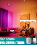 Couple using 6 Inch Smart Recessed Lighting Kit With Remote And WiFi Color Changing RGBCW Canless Recessed Ceiling Lights 15W 1100LM with Alexa voice control in a living room.
