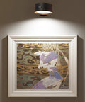 Rechargeable Battery Operated Wall Sconce Twin Pack With 3 White And 13 RGB LED Lights illuminating framed art on wall