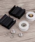 22mm Greenhouse Door Wheel Replacement Kit For Sliding Doors with black brackets, white wheels, and screws on wood surface