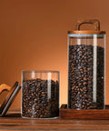Premium Glass Coffee Canister With An Airtight Wooden Lid To Keep Your Daily Grind Fresh Kitchen Counter Storage Jars filled with coffee beans.