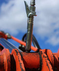 Grease Gun Coupler XL Universal Fit With 3.5 Inch Extra Reach for recessed fittings, attached to orange machinery, locking jaws visible