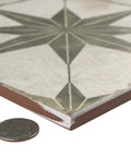 Close-up of Kings Star Sage Seventeen And Five Eighths Inch Ceramic Floor And Wall Tile showing thickness and star pattern with coin for scale.