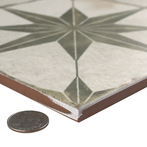 Close-up of Kings Star Sage Seventeen And Five Eighths Inch Ceramic Floor And Wall Tile showing thickness and star pattern with coin for scale.