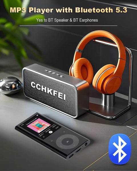 64GB MP3 Player With 2.4 Inch Screen And Built In Speaker Bluetooth Hi Fi Sound next to orange headphones and speaker.