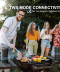 Outdoor party with a man grilling and four people enjoying music from Rugged Portable Bluetooth Speaker With 24W Stereo Sound IPX7 Waterproof.