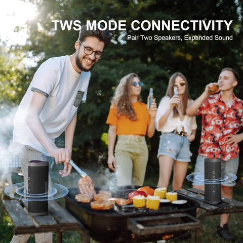 Outdoor party with a man grilling and four people enjoying music from Rugged Portable Bluetooth Speaker With 24W Stereo Sound IPX7 Waterproof.