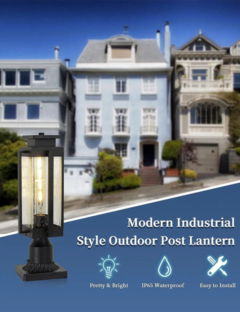 Heavy Duty 18 Inch Outdoor Post Light Lantern With Pier Mount Base, IP65 Waterproof Black Finish And Seeded Glass in front of houses.