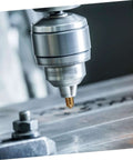 Close-up of flute steel chamfering cutter in milling machine cutting metal workpiece