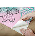 Hands peeling Under The Sea Blue Peel And Stick Wall Mural For Kids Rooms By RoomMates showing adhesive back