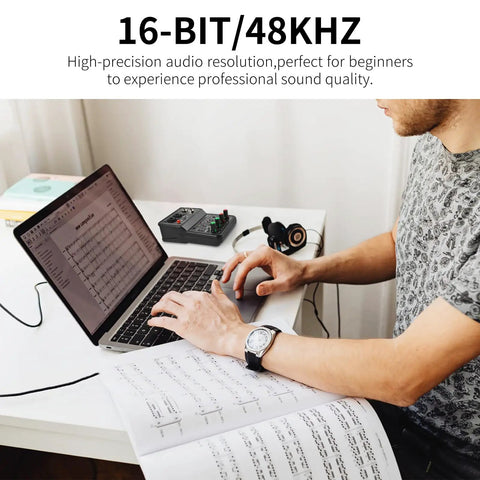 Person using Q-12 USB Audio Interface For PC With XLR And 3.5mm Microphone Jack For Home Studio Recording next to laptop