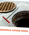 Heavy Duty Multi Function Manhole Cover Lifter With Thick T Shaped Handle For Roller Shutters And Sliding Doors Top Notch No Sweat Pulling Tool Set Pro Grade near an open manhole.