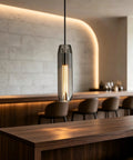 PRTSER 11.8" Modern Pendant Light Fixture with Smoke Gray Crystal Lampshade hangs over a wooden bar counter.