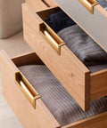 Wooden drawers with gold handles showing modern design and storage capability, emphasizing the elegant hardware and functionality.