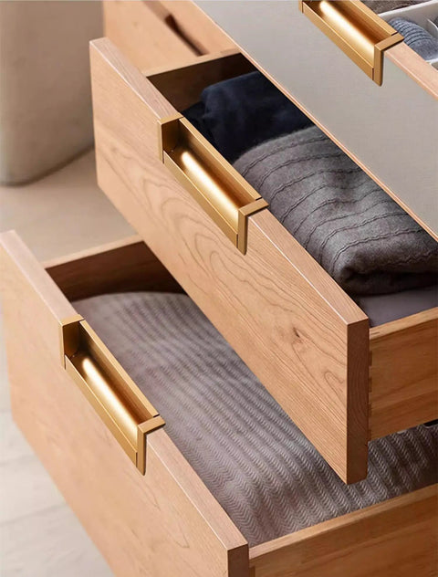 Wooden drawers with gold handles showing modern design and storage capability, emphasizing the elegant hardware and functionality.