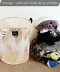 Collapsible Laundry Hamper Basket With Handles Waterproof Liner Round Cotton Linen Fabric next to a pile of clothes