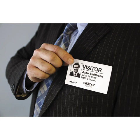 Man in a suit holding a visitor badge, showcasing Ultra Fast Network Label Printer With Bluetooth And Ethernet Wireless Connectivity Slick Monochrome Printing Up To One Hundred Ten Labels Per Minute Dead Simple Setup For Professional Workflows.