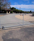 Heavy Duty Galvanized Steel Rolling Gate Hardware Kit With Slick 6 Inch Double Track Wheels and Six Wall Mount Brackets Plus Solid Rolo Latch For Chain Link Sliding Gates, installed on a gravel driveway.