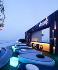 Outdoor lounge setting with 16 Inch LED Cube Chair Light With 16 RGB Colors Glow Cube Seat near shore bar at twilight