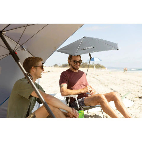 Two men on the beach under Versa-Brella SPF 50+ Adjustable Umbrella With Universal Clamp For On-The-Go Shade, regular size gray.