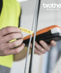 Person using an orange Entry Level Industrial Handheld Labeling Tool Kit For 12mm Labels Orange, Rugged On The Go Label Printer