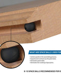 Close-up of black synthetic rubber panel spacer in wood channel. Wood Door And Panel Expansion Spacers 0.26 Inch Diameter Prevent Panel Cracking And Rattle From Humidity Changes Ensure Centered Panels With Even Spacing Of Two To Three Spacers Per Channel.