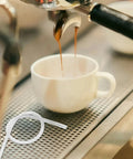 Espresso machine pouring into cup with Six Pack Milk Frother Hose Replacement Kit With Three Connectors beside it.