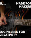 Person playing a custom 3D-printed electric guitar with bold orange and black design, emphasizing creative engineering.