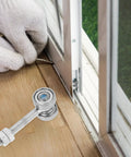 Tough As Nails Dual Wheel Sliding Door Roller Pulley with Double Bearings being installed with glove on a wooden floor.