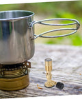 Portable Gas Blowtorch Head For Camping And Outdoor Cooking next to a pot on outdoor table, brass propane burner, adjustable flame.