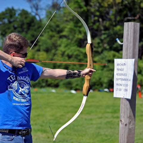 Archer using premium 30 inch carbon hunting arrows with real 4 inch turkey feather fletching at practice range.